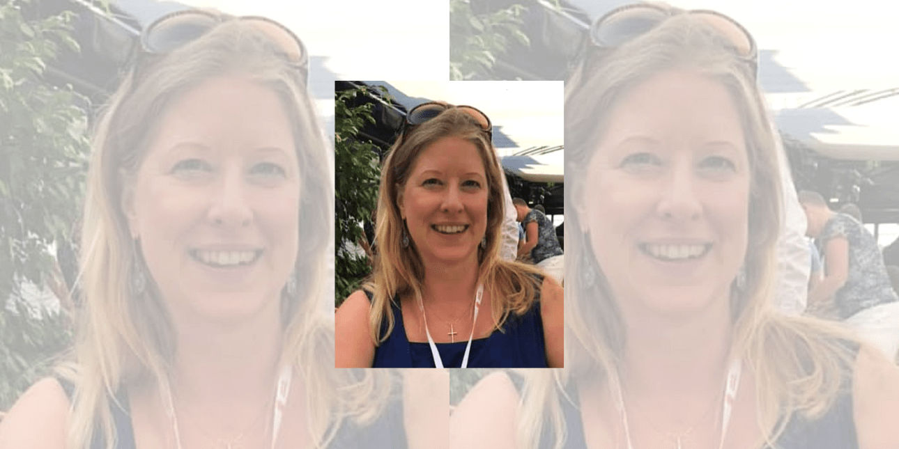 A portrait of Caroline Klein with mountains in the background. Caroline is a blonde white woman wearing a blue vest top with sunglasses on her head and a white lanyard.