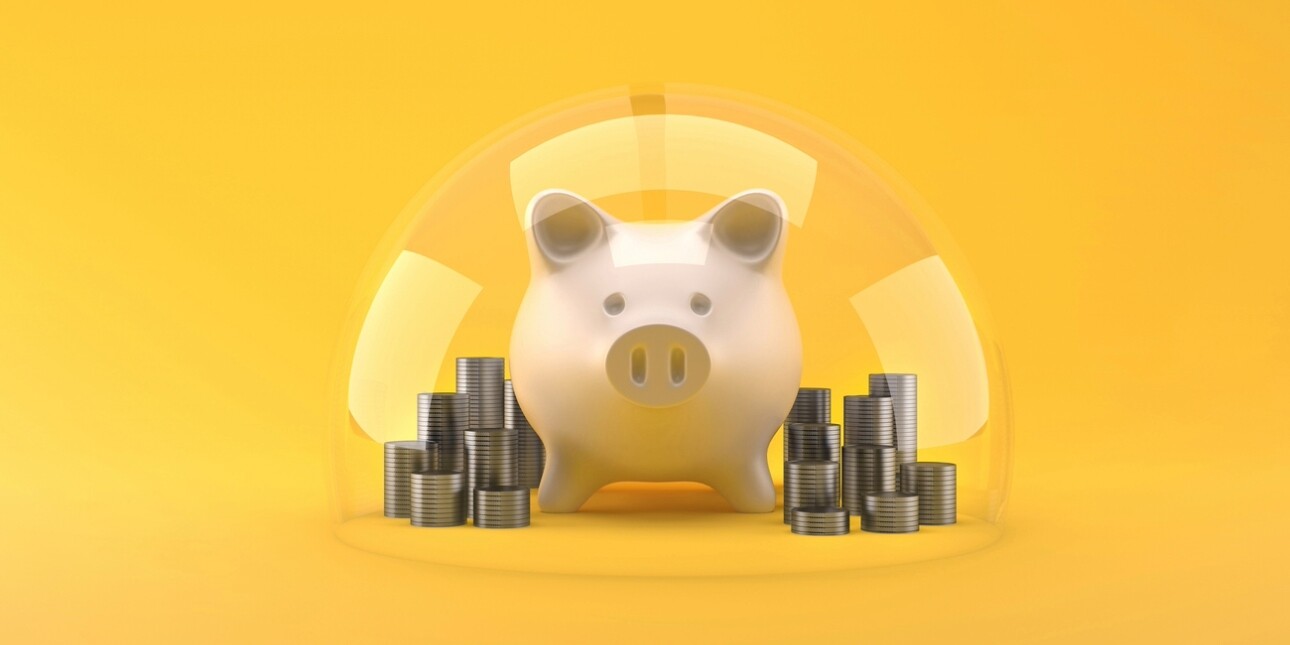 A digital illustration on a yellow background a pink piggy back surrounded by stacks of coins under a transparent dome
