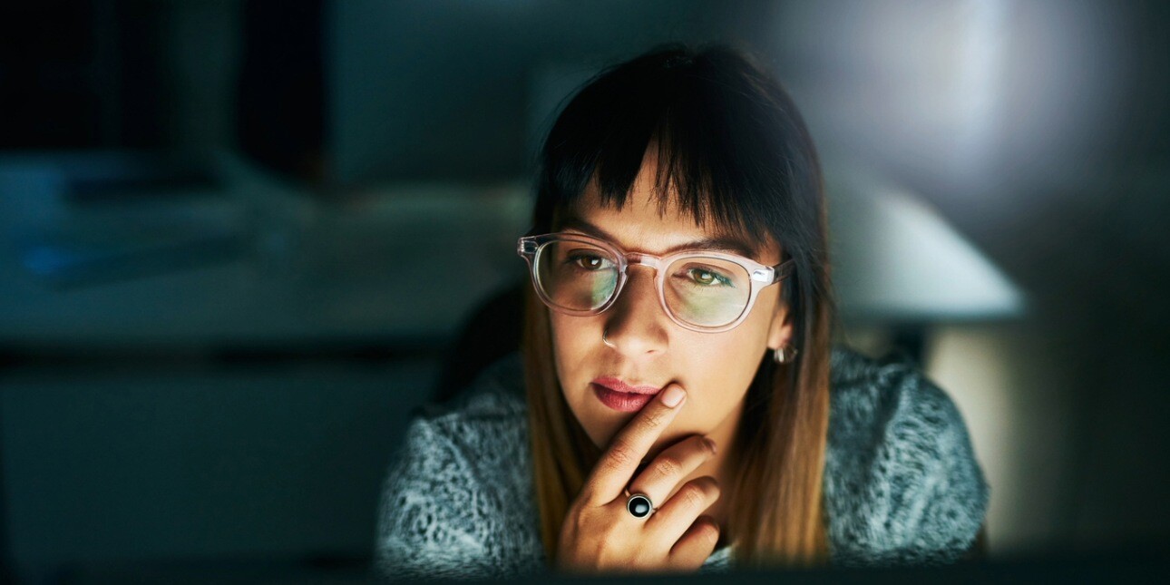 High angle shot of a businesswoman looking thoughtful while working on her computer late at night in the office