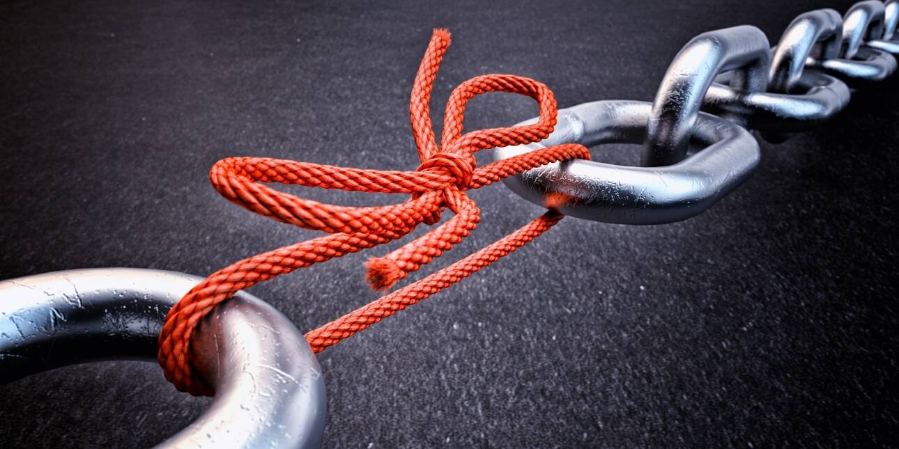 Metal chain links held together by red string