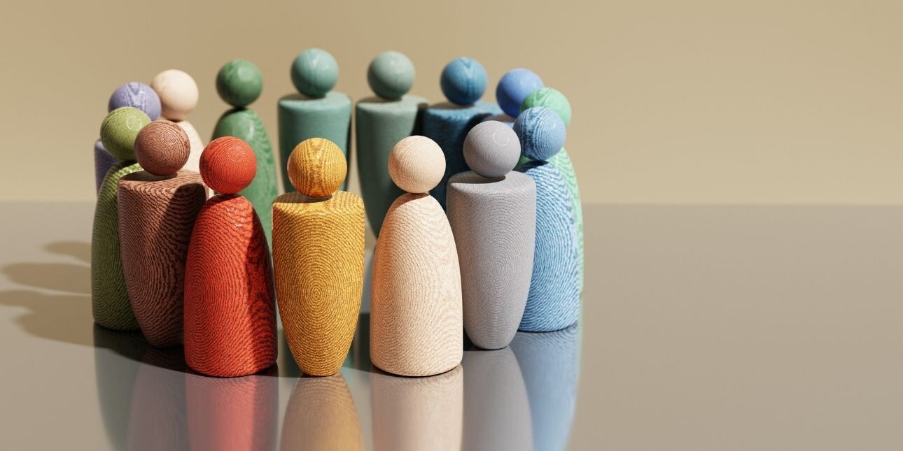 A circle of 15 wooden figures painted in different colours