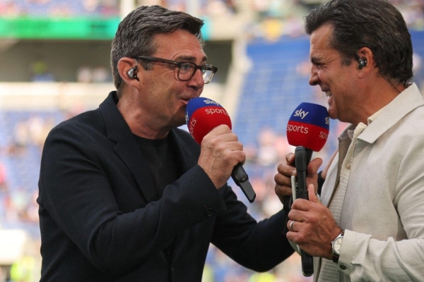 Andy Burnham in light hearted conversation with Brian Carvey on the pitch a rugby league stadium.