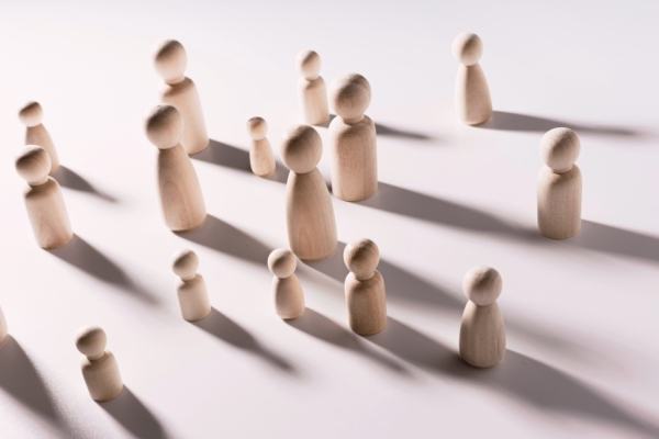 An assortment of different sized wooden figures on a pink background