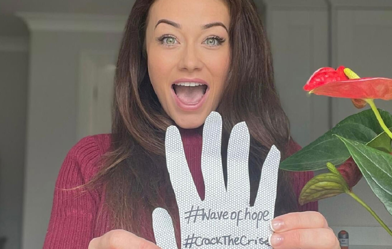Jess Impiazzi holding a hand drawn hand.