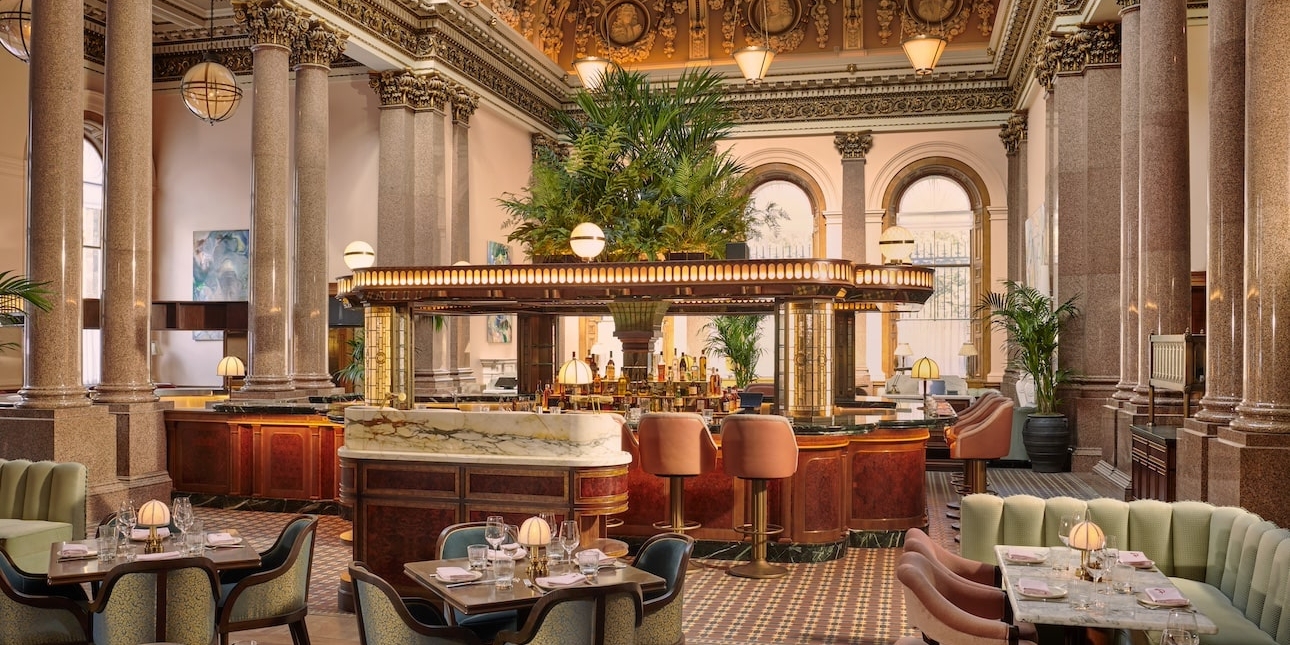 The opulent canopied bar and dining room at Gleneagles townhouse with marble pillars, friezes and a large palm. Decoration and furnishings are mostly pistachio green and pastel pink