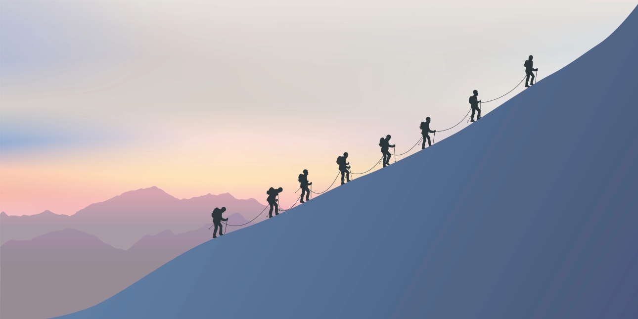 Silhouettes of eight mountain climbers linked by a rope making their way up a 45-degree angled mountain slope
