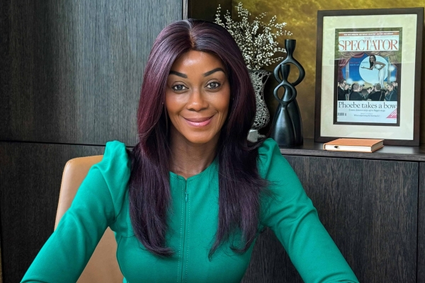 Phoebe Vela-Hitchcox sitting at a desk staring at the camera