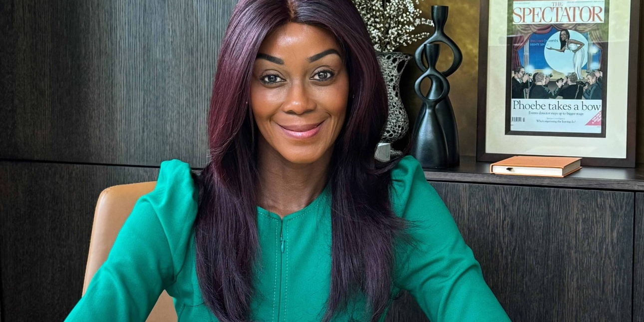 Phoebe Vela-Hitchcox sitting at a desk staring at the camera