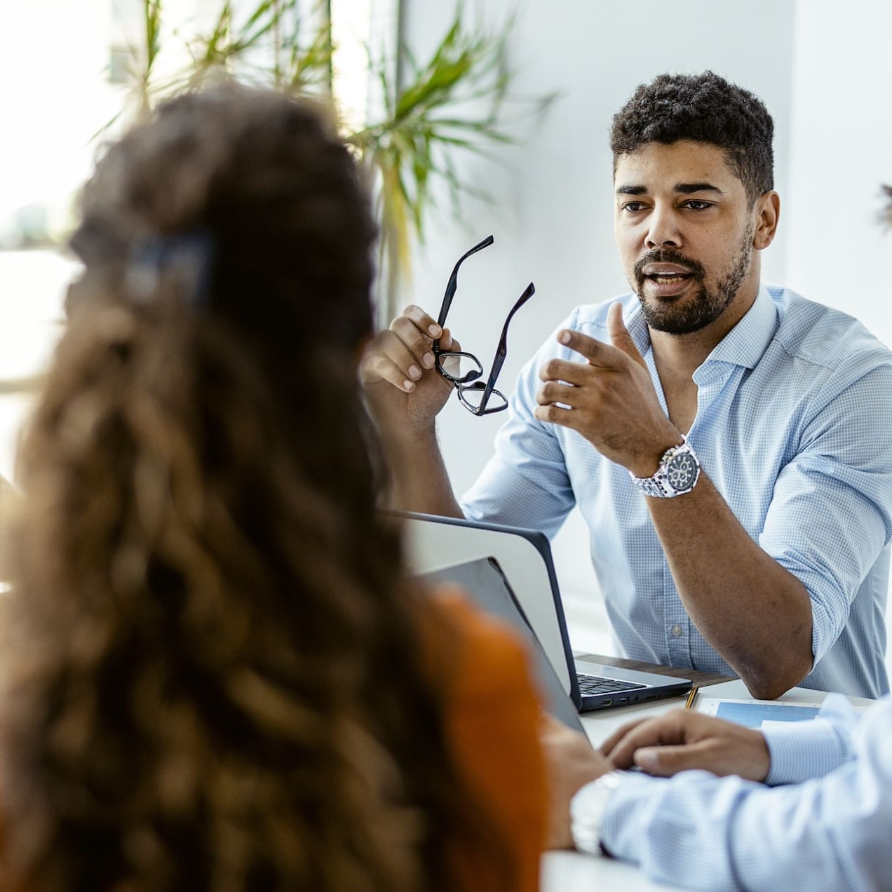 Four colleagues of different genders and ethnicities sit around a table in discussion