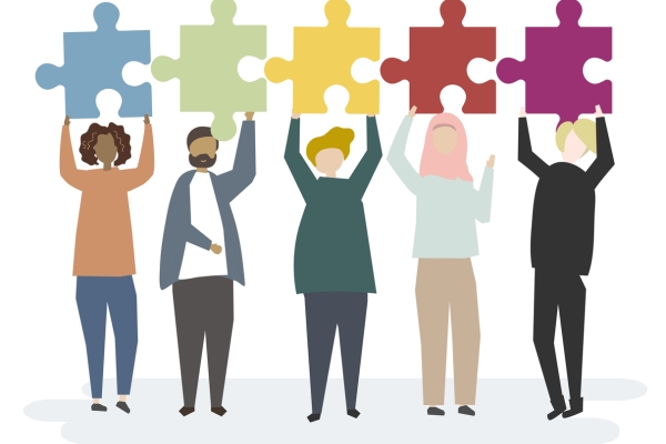 Illustration of five people with different skin tones and hair colour, including one wearing a hijab. Each holds up a large coloured jigsaw piece.