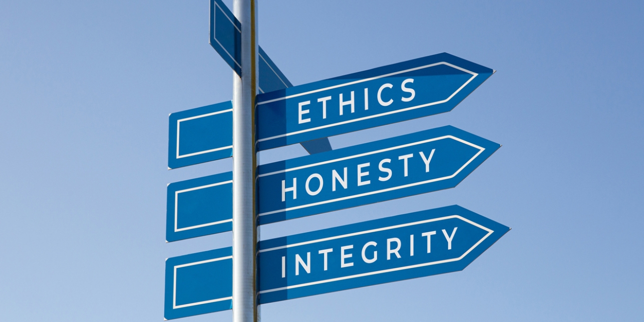 Three directional signs on a post with the words ethics honesty integrity written on them