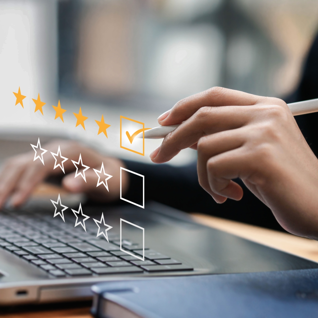 A hand holding a stylus is ticking a box next to five yellow stars. Below it are boxes with four and three white outlined stars. These stars are superimposed over a laptop keyboard