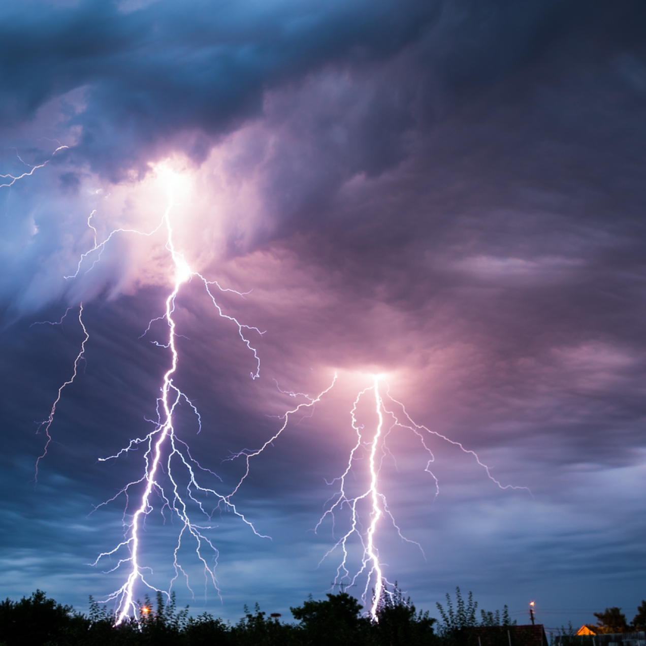 Dark thundery clouds lit up in places by several lightning bolts