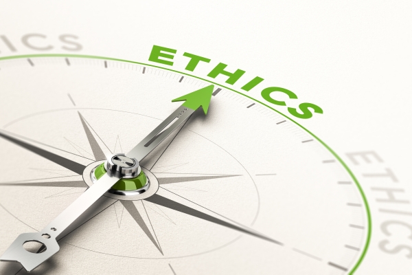 A silver compass needle pointing at the word ethics. The tip of the needle and the word are in green.