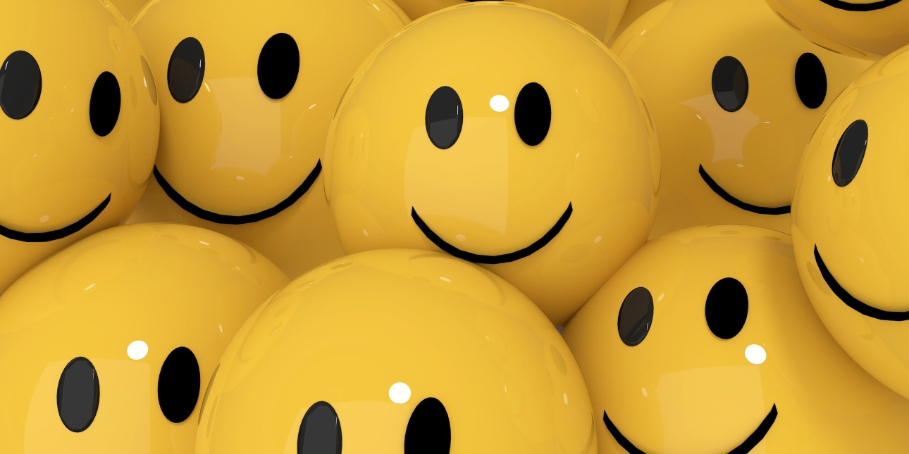 A selection of bright yellow balls with smiley faces