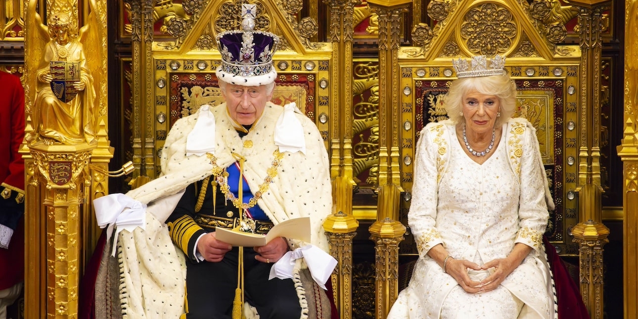 King Charles and Queen Camilla in robes sat on thrones in the House of Lords at 2023's state opening of parliament