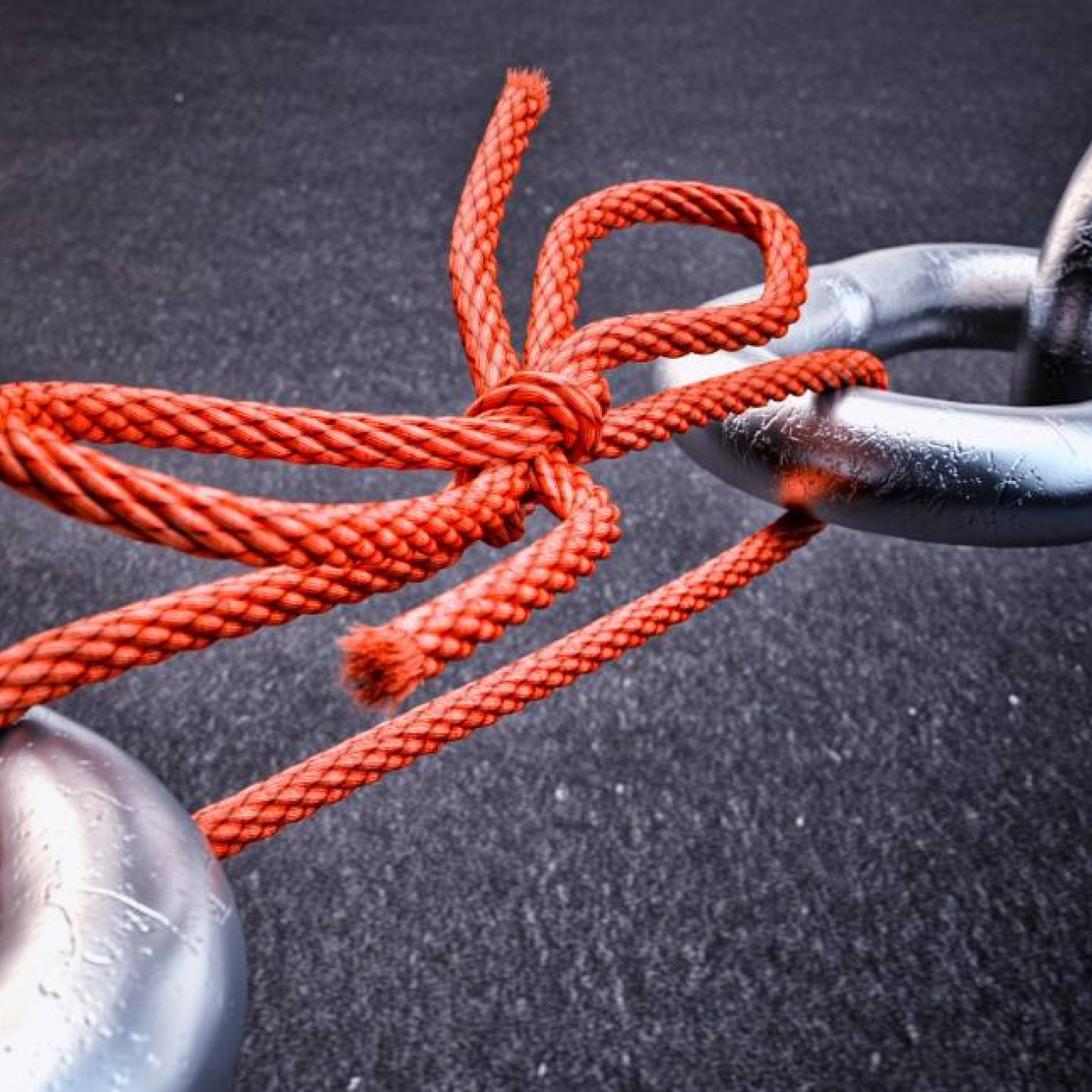 Metal chain links held together by red string