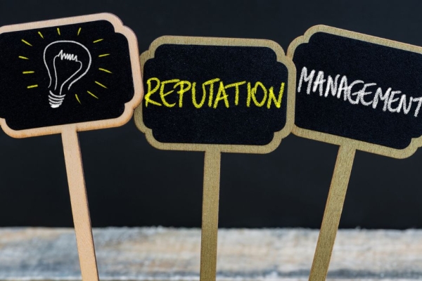 Three chalkboard signs in a row featuring a lightbulb illustration and the words reputation and management