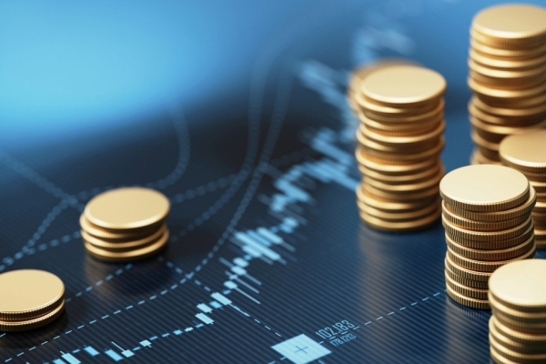 Seven stacks of coins of different heights sat on a blue financial graph.