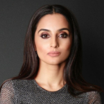 A colour portrait of Farzana Baduel on a dark background. 