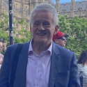 A colour portrait of Peter Osborne. Peter is a white man with grey hair wearing a grey suit.