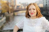 Louise Turner stood on a bridge over a river. Louise is a white woman with light brown hair and white top
