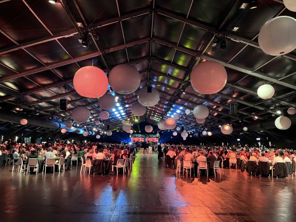 Dozens of employees sat at tables at a conference venue at Disneyland Paris with large lamp shades hanging from the ceiling