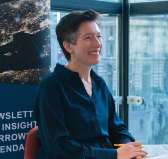 A side profile of Anna Pedroza sat in front of a window. Anna wears a navy shirt.