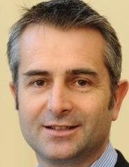 Head shot of Tom McLaughlin, a white man with dark brown and grey hair.