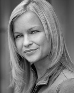 A black and white photograph of Lucy Morgans' head and shoulder. Lucy is looking sideways at the camera.