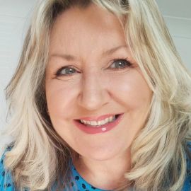 A smiling Amanda Little. Amanda is a blonde haired white woman