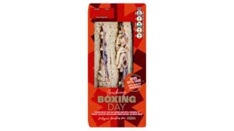 Pre-packed red carboard packet with a clear panel showing a Boxing Day sandwich with labeling on the front