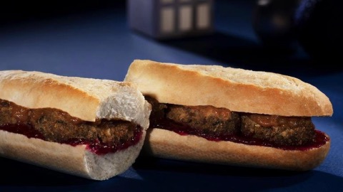 White baguette filled wiht brown and red filling on a blue table top