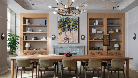 The Bloom Room atr the Montcalm Hotel whiich is a privatre dining room with a table and chairs set out in a bright room with bookshelves, a painting on the wall and a decorative ceiling light