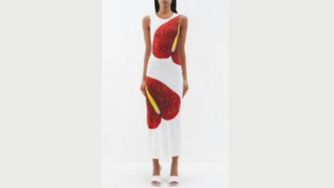 A headless model wears a sleeveless mid-length red and white dress wiht a yellow slash and white sandals