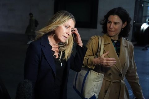 Deborah Turness with her left hand steadying her hair as she walks alongside another woman.